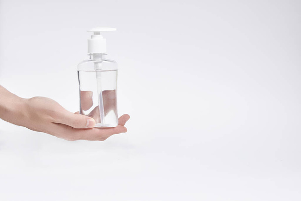 transparent bottle or bottle with liquid with dispenser in hands on a white background. copyspace - Photo, image