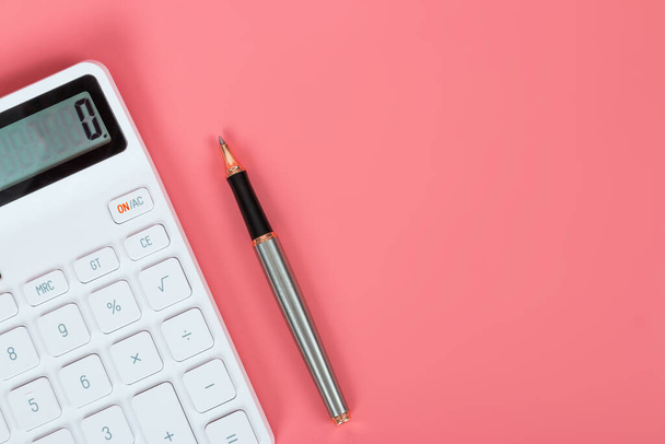 Weißer Taschenrechner und Stift auf hellrosa Hintergrund, Marketing- und Finanzkonzepte - Foto, Bild