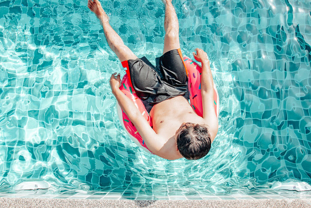 Koncepcja wakacje i wakacje Mężczyzna na ringu pływackim w basenie w ciągu dnia Szczęśliwy i zrelaksowany - Zdjęcie, obraz