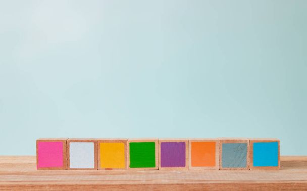 Blocos de madeira de muitas cores dispostos em uma mesa de madeira, tons Pastel
 - Foto, Imagem
