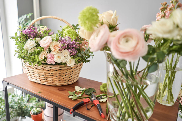 Education in the school of floristry. Master class on making bouquets. Summer bouquet in a wicker basket.. Learning flower arranging, making beautiful bouquets with your own hands. Flowers delivery - Photo, image
