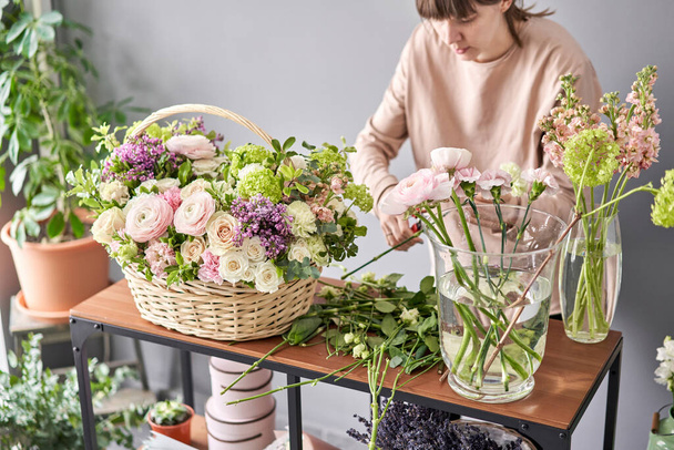 Education in the school of floristry. Master class on making bouquets. Summer bouquet in a wicker basket.. Learning flower arranging, making beautiful bouquets with your own hands. Flowers delivery - Zdjęcie, obraz