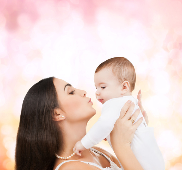 Szczęśliwa matka całuje swoje dziecko - Zdjęcie, obraz