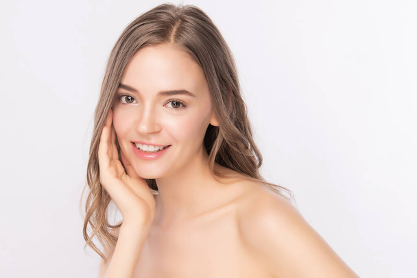 Kaunis nuori nainen koskettaa hänen puhtaat kasvonsa tuoreella terveellä iholla, eristetty valkoisella taustalla, kauneus kosmetiikka ja kasvohoito Concept
. - Valokuva, kuva