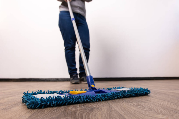 mop closeup in the hands of a man. general cleaning in the apartment and office. - Photo, Image