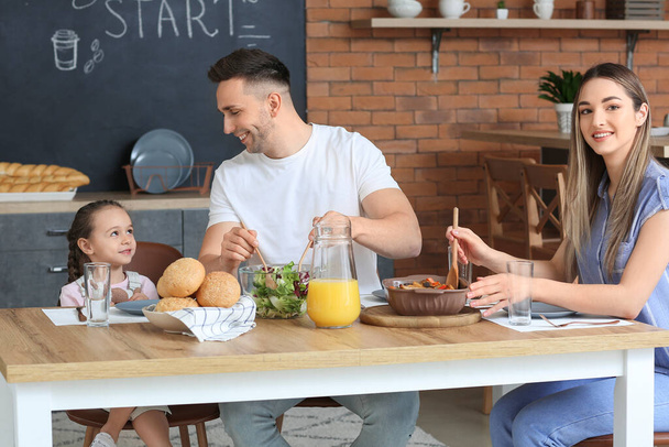 Família feliz jantando juntos na cozinha
 - Foto, Imagem