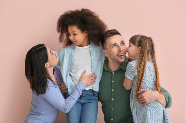 Happy couple with little adopted children on color background - Foto, Imagem