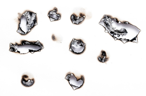 Agujeros quemados en un pedazo de papel
 - Foto, imagen