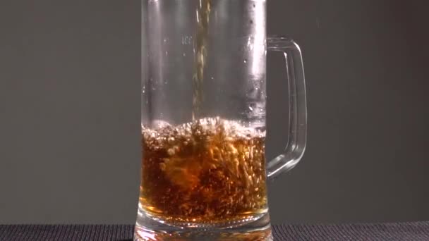 Μπάρμαν ρίχνει μπύρα σε ποτήρι με φυσαλίδες κοντά. Σε σκοτεινό φόντο - Πλάνα, βίντεο