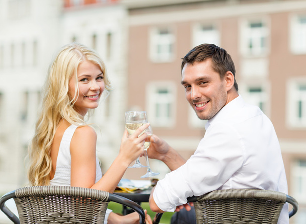 Smiling couple drinking wine in cafe - 写真・画像