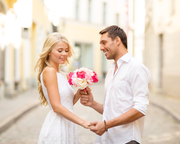 Couple with flowers in the city - Fotoğraf, Görsel