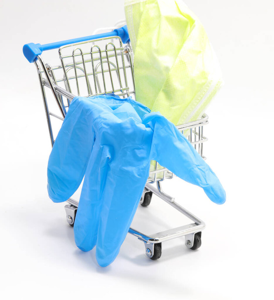 Medical equipments to defend against coronavirus in a small shopping trolley with mask and gloves on a white background - Foto, Bild