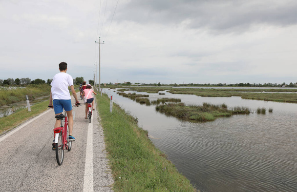 Мальчик со своей семьей на дороге с велосипедами
 - Фото, изображение