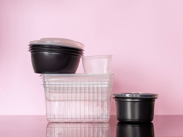 Plastic containers on a pink background. Recycling plastics. Reusable packaging. Disaster planet trash harm the environment. Sorting garbage concept. Zero waste. Single  one use stop - Foto, afbeelding