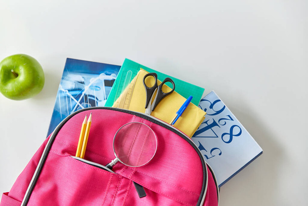 backpack with books, school supplies and apple - 写真・画像
