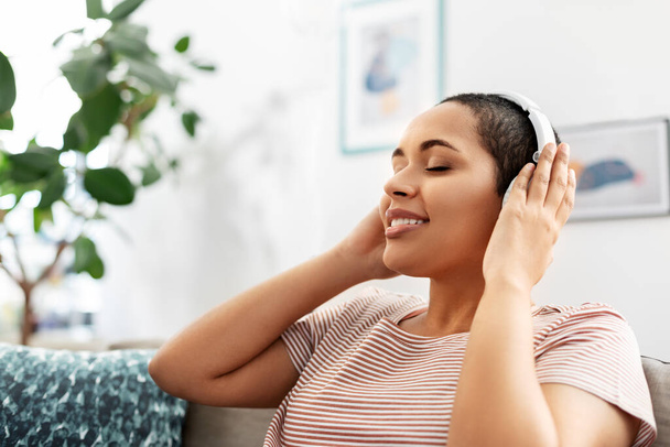 woman in headphones listening to music at home - Fotó, kép