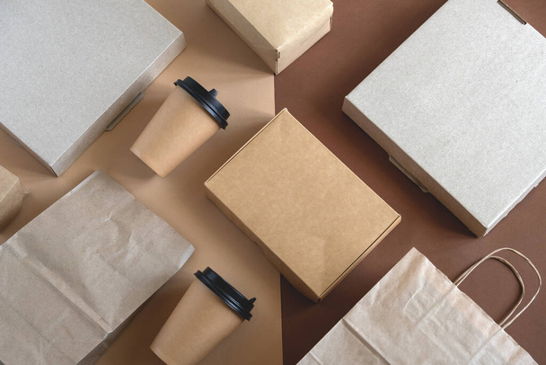 top view flat lay disposable blank delivery food packaging on a beige and brown background - Foto, afbeelding