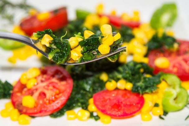 fork with spinach and corn with tomato salad and spinach background, diet concept - Fotoğraf, Görsel