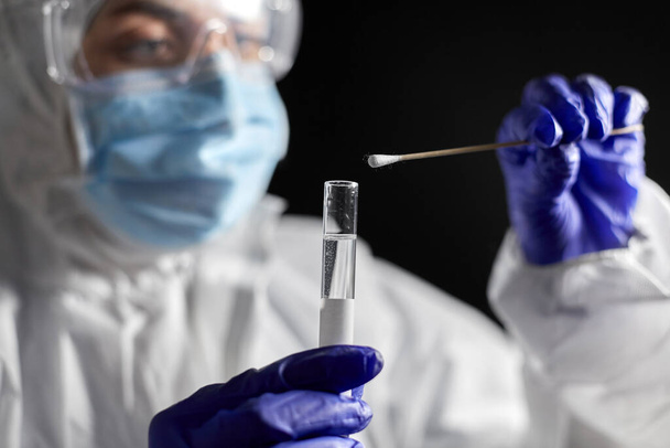 scientist holding beaker with coronavirus test - Foto, Imagem