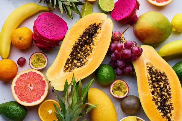 Healthy summer tropical exotic fruits on white table, top view  - 写真・画像