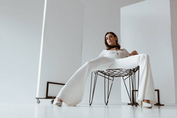 Beautiful young woman dressing white sitting on chair - Фото, зображення