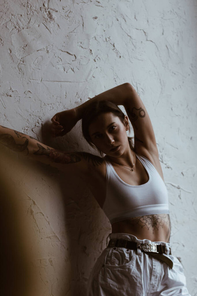 Sexy woman with tattoos wearing cotton bra and white jeans - Φωτογραφία, εικόνα