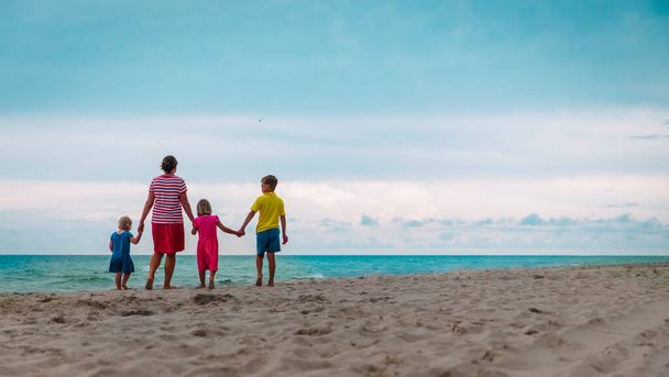 Mutter mit Kindern spazieren am tropischen Strand - Foto, Bild