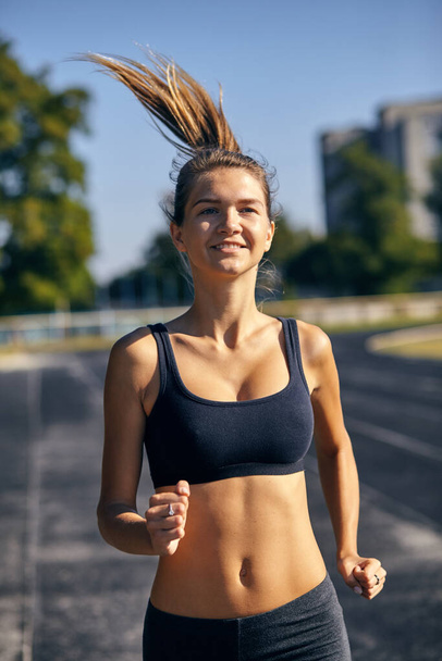 Athletic woman on track starting to run - Fotoğraf, Görsel
