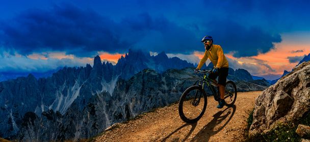Ciclismo aventura al aire libre en Dolomitas. Mujer ciclista y hombre en bicicletas eléctricas de montaña en el paisaje Dolomitas. Un par de ciclismo MTB pista de enduro trail. Actividades deportivas al aire libre
. - Foto, Imagen