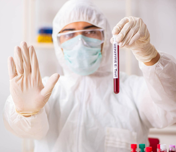 Jonge knappe lab assistent die bloedmonsters test in het ziekenhuis - Foto, afbeelding