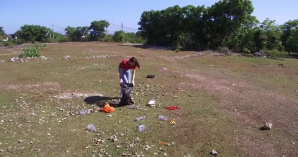 Woman picking up plastic bottles from the meadow. Photo of environmental activist collecting plastic garbage. Volunteer picking up single used plastic outdoor. - Footage, Video