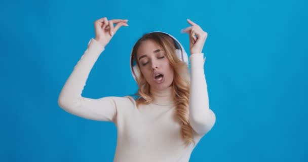 Woman enjoying music in wireless headphones and dancing - Filmati, video