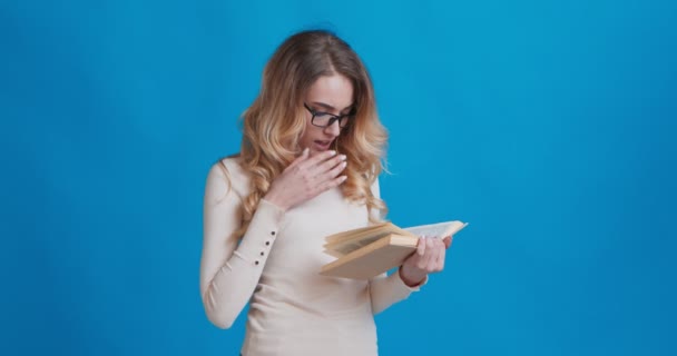 Young concentrated woman reading book, self education - Materiał filmowy, wideo