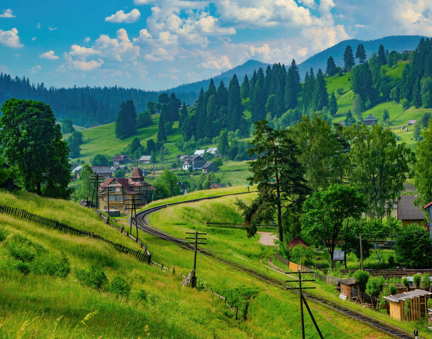 Scenic view of mountain resort Vorokhta in Carpathian Mountains at sunny summer day. Winding railway. Ivano-Frankivsk region, Ukraine - Photo, Image