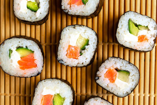 Sada sushi rolls na pozadí sushi mat, detailní záběr, horní pohled - Fotografie, Obrázek
