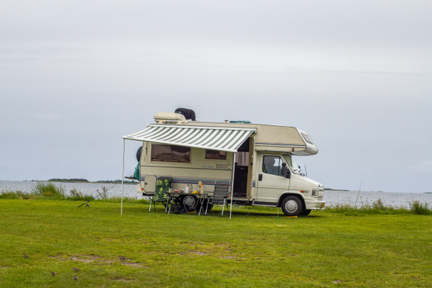 Casa móvil en una costa marina cubierta de hierba en un día gris lluvioso de verano
 - Foto, Imagen