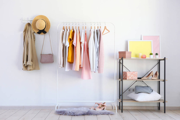 fashionable clothes on a rack in a bright interior of the wardrobe room - Foto, Imagem