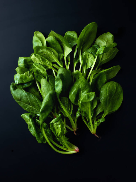 Heap of spinach leaves on black background, top view - Foto, Bild