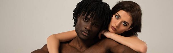 sensual interracial couple hugging isolated on grey, panoramic concept - 写真・画像