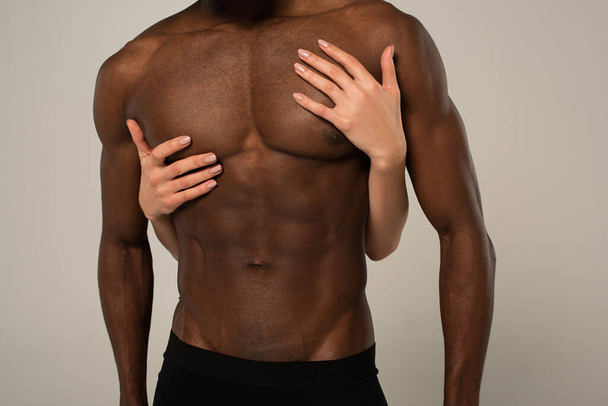 cropped view of girlfriend hugging muscular shirtless african american boyfriend isolated on grey - Photo, Image