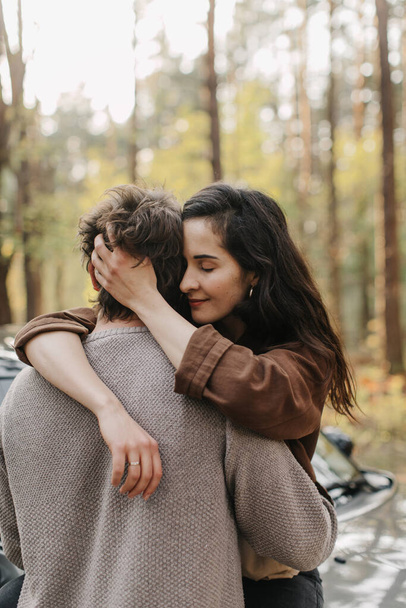 Bella giovane coppia innamorata baci e abbracci seduta su una macchina
 - Foto, immagini