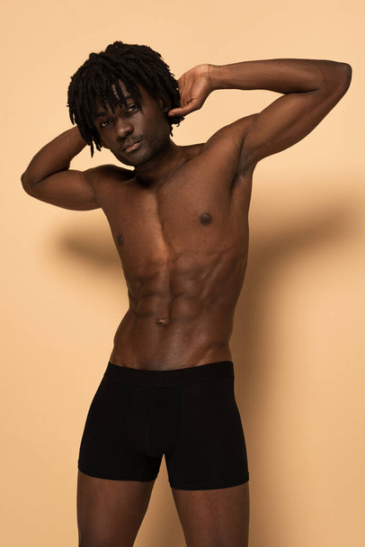 sexy muscular shirtless african american man on beige - Fotografie, Obrázek