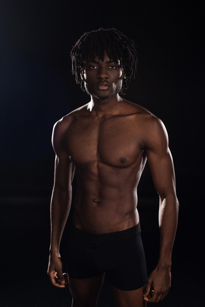 handsome shirtless african american man isolated on black with back light - Foto, afbeelding
