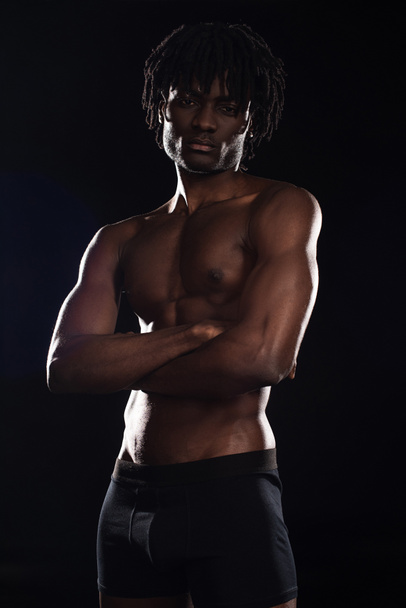 homme américain musclé torse nu avec les bras croisés isolé sur noir
  - Photo, image