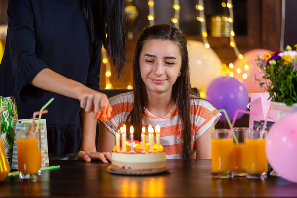 Hyvää teini tyttö ja äiti syntymäpäivä kakku vuosipäivä juhlissa. Valaistus kynttilöitä syntymäpäivä kakku
.  - Valokuva, kuva