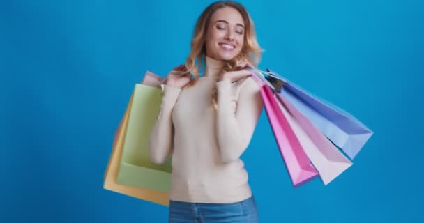 Gyönyörű boldog szőke lány táncol bevásárló táskák - Felvétel, videó