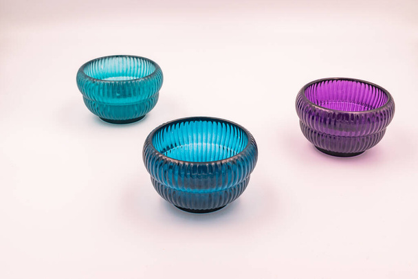 Foto de cerca de tres artículos de decoración para el hogar de vidrio de color azul y púrpura modernos y minimalistas, candelabros
 - Foto, imagen