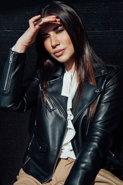 Beautiful fashionable eastern brunette woman in black leather jacket - Foto, afbeelding