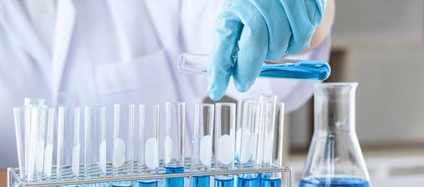 Biochemistry laboratory research, Chemist is analyzing sample in laboratory with equipment and science experiments glassware containing chemical liquid. - Foto, Bild