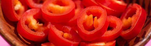 panoramisch shot van rode en kruidige chili pepers in kom - Foto, afbeelding